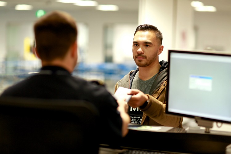 Passport officer handing pack a passport